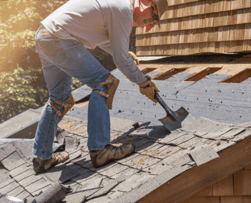 A professional roofing contractor working on a roof replacement project.