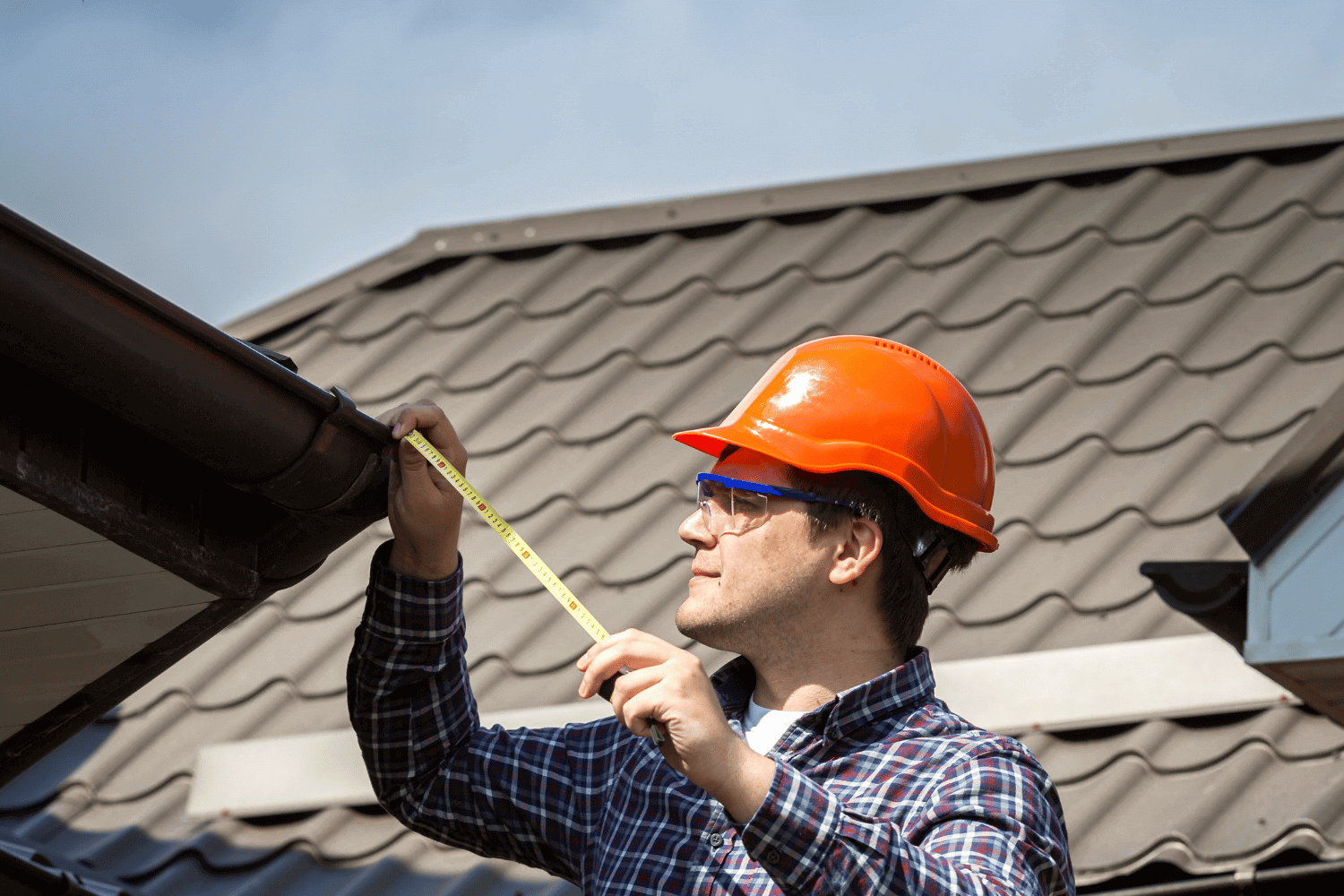 A person measuring the roof slope with a tool, demonstrating the process of measuring roof slope