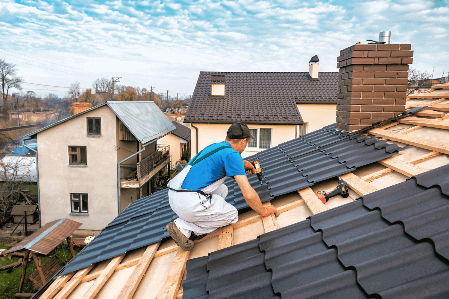 A photo showing a professional inspecting a metal roof for potential wind damage