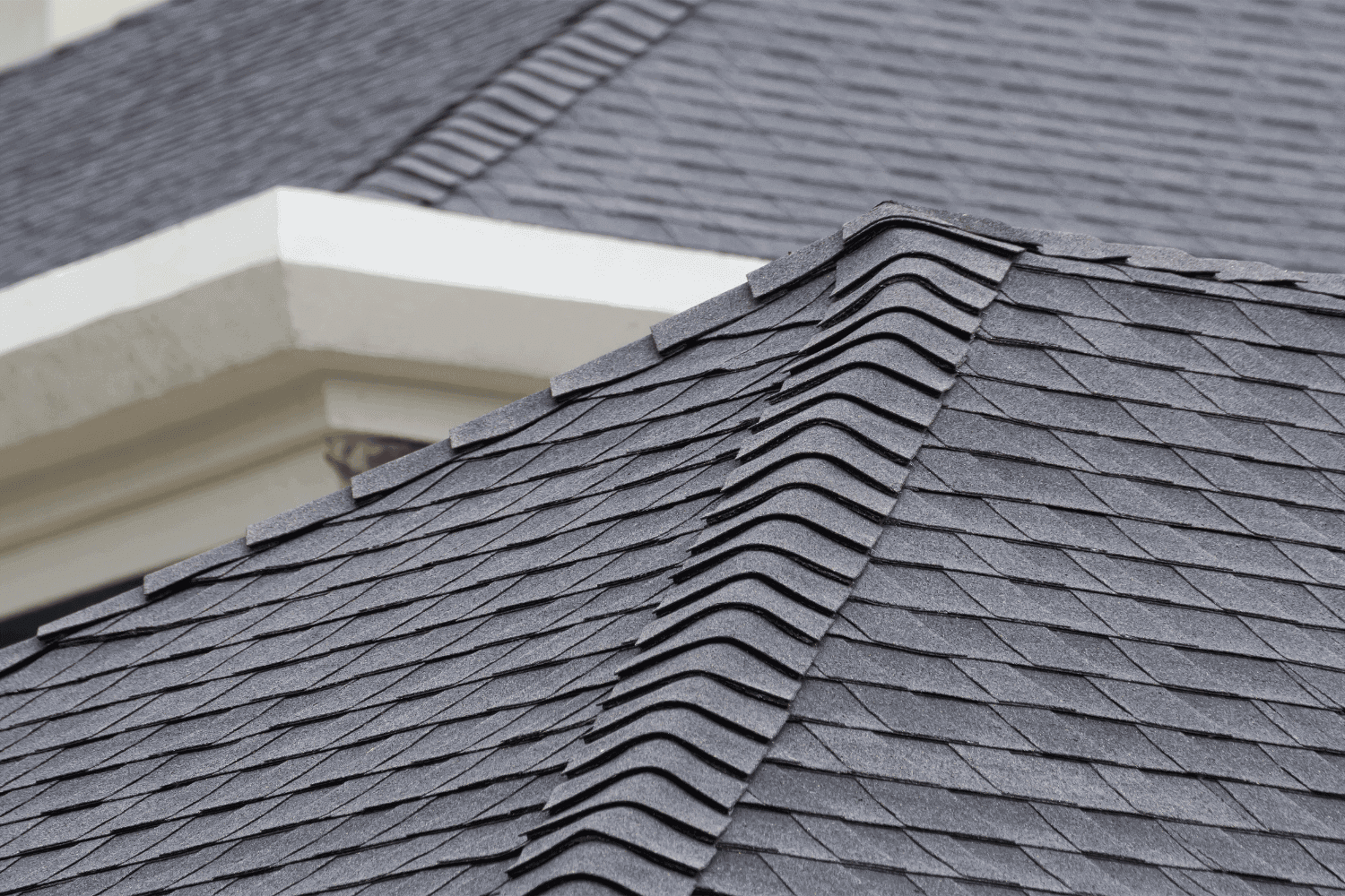 Ridge cap shingles being placed on a newly shingled roof