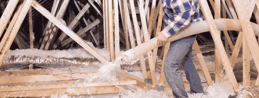 A person carefully walking in an attic filled with blown insulation..