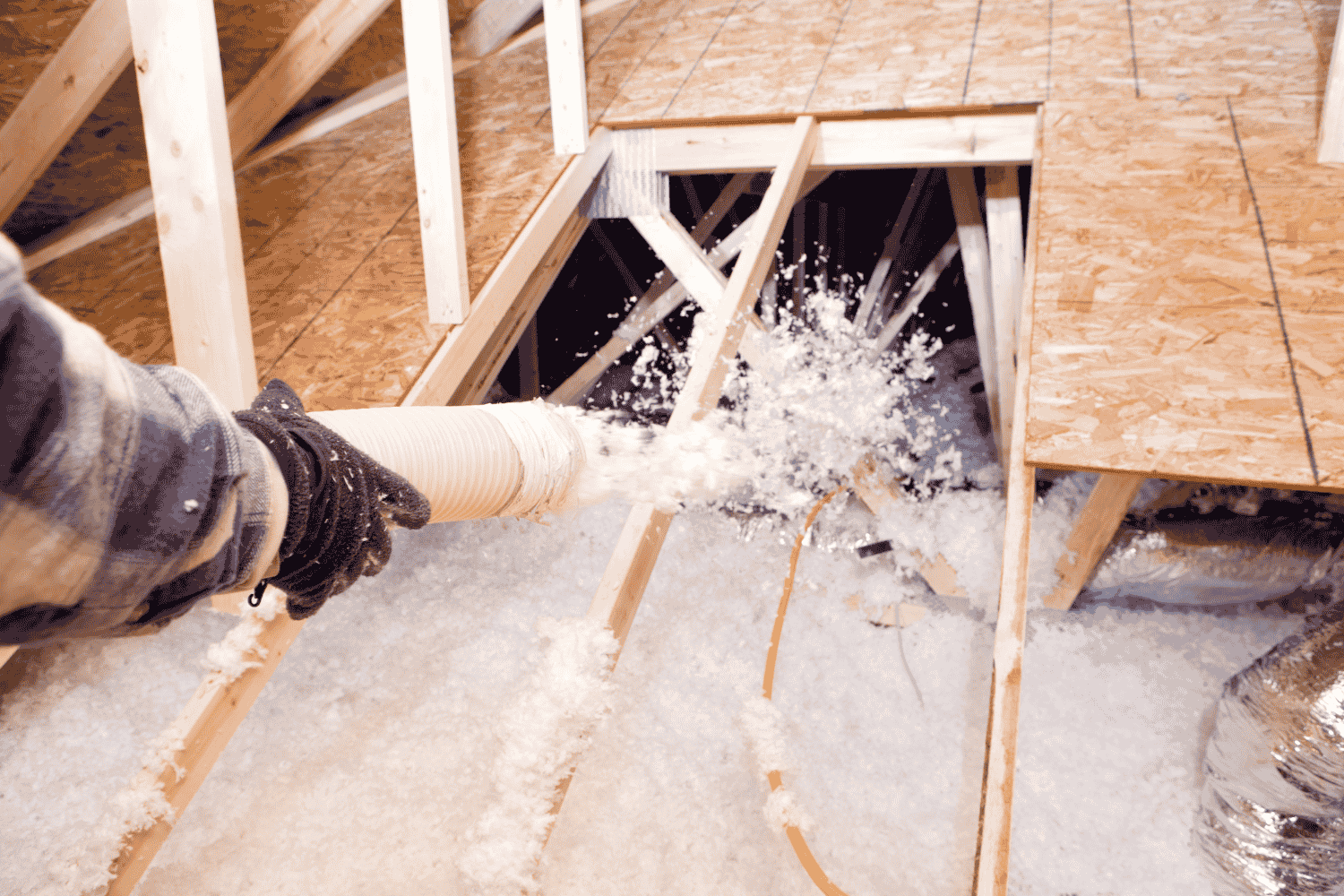 How to Efficiently Install Loose Fill Insulation by Hand 2 A person preparing their attic area for insulation work.