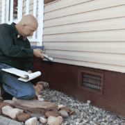 Inspecting the exterior of a home for foundation issues.