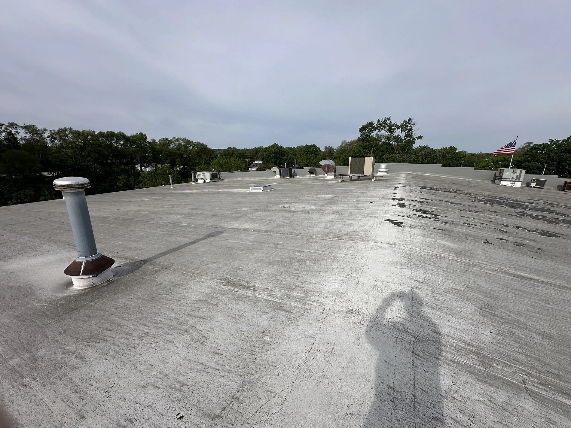 Will Regular Commercial Roof Maintenance In South Bend, IN Protect Your Business 2 A wide view shows a large, weathered flat commercial rooftop equipped with vents and HVAC units, highlighting a structure that would benefit from scheduled commercial roof maintenance.