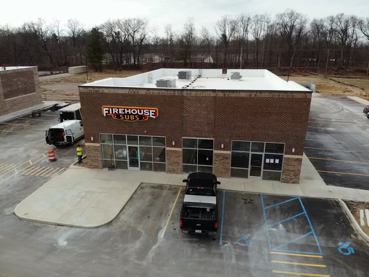 Silver Lake, IN 2 An aerial shot captures a Firehouse Subs restaurant building with a clean, flat commercial roof, showing the type of retail property that relies on expert commercial roofing services.