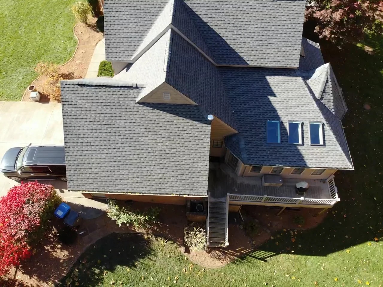 Bristol, IN 3 An overhead aerial view captures a large residential home featuring a complex multi-gabled architectural roofline with dark shingles and three skylights, showcasing a property enhanced by professional exterior services.