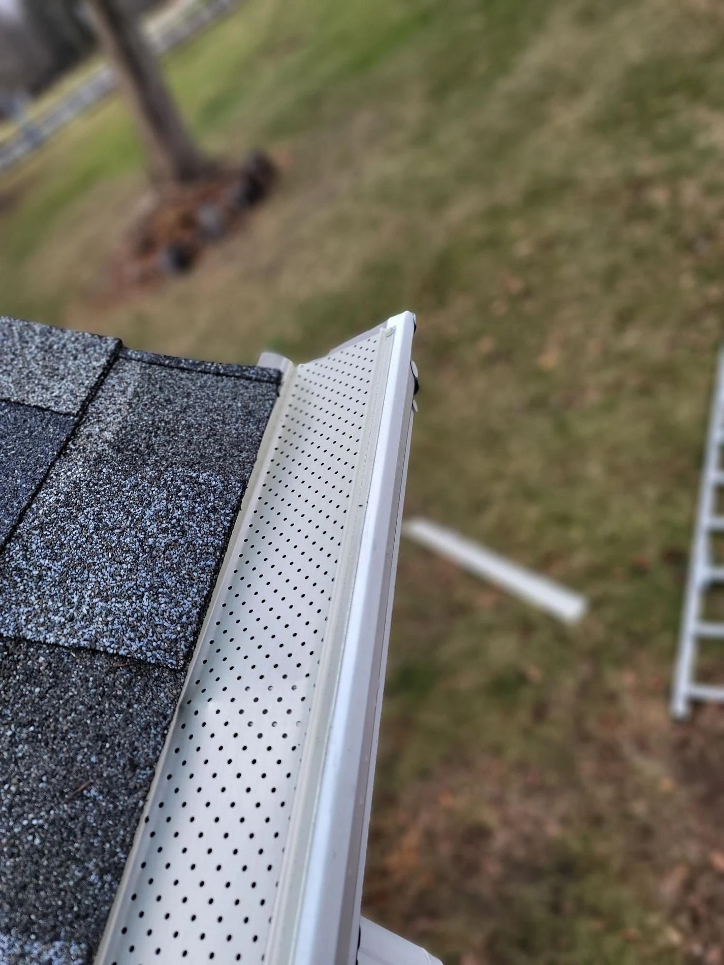 Osceola, IN 3 A close-up view highlights a pristine white gutter fitted with a perforated guard system along the roof edge, showcasing the lasting protection provided by professional gutter services.