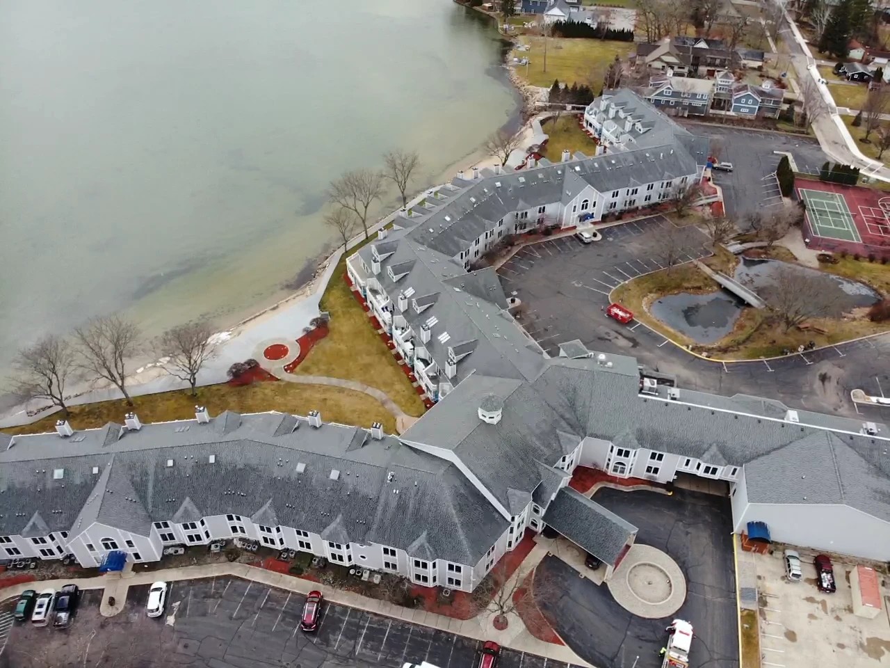An aerial view showcases a massive lakeside multi-family complex with extensive shingled rooflines, highlighting a large-scale property suited for professional commercial roofing services.
