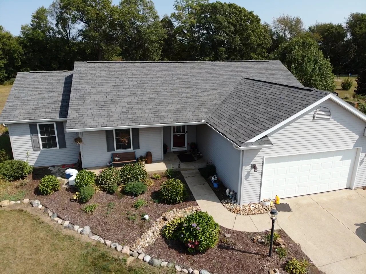 Granger, IN 3 An aerial view shows a charming ranch-style home with light vinyl siding, landscaping, and a well-maintained shingle roof that underscores the value of quality exterior services.