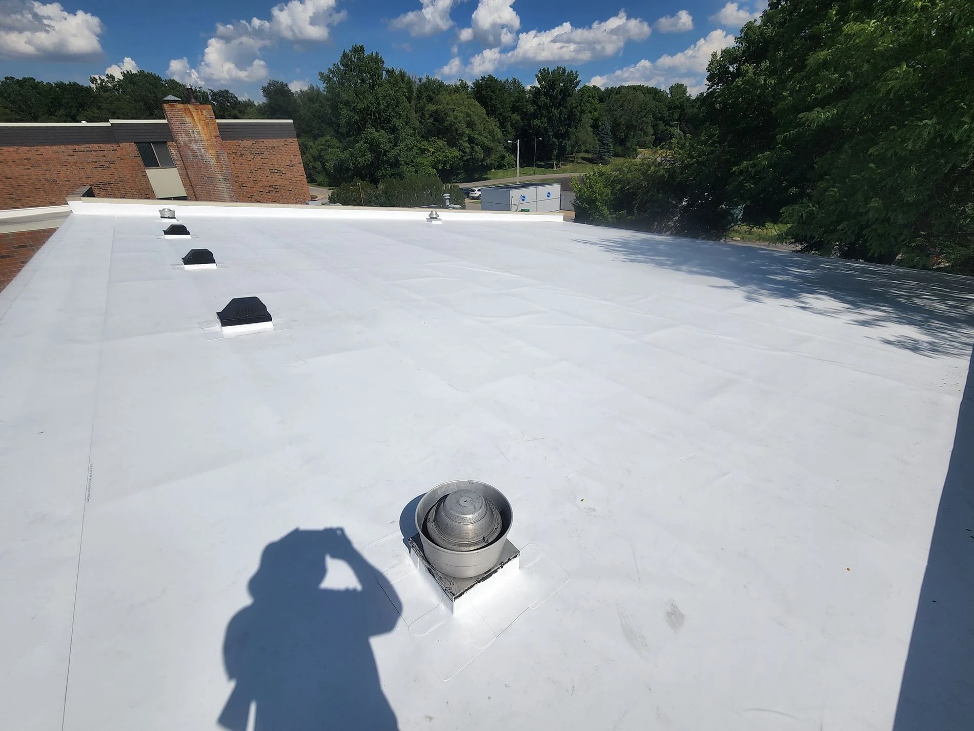 North Liberty, IN 2 A high-angle view reveals a wide, cleanly installed white flat roof system on a commercial building complete with integrated vents, demonstrating the precise workmanship delivered by professional commercial roofing services.