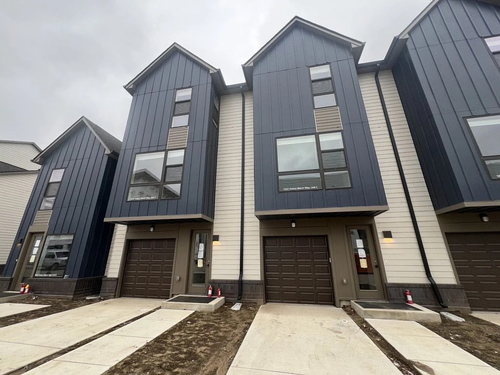 Wakarusa, IN 2 Modern multi-level townhomes feature sleek vertical blue siding and gabled rooflines crafted with professional roofing services.