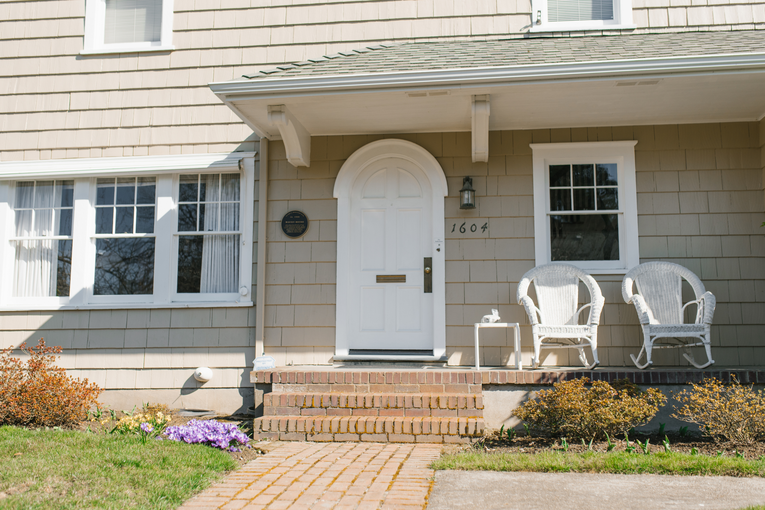 Winamac, IN 3 Classic white-trimmed windows frame a home's front entrance, highlighting professional window services.