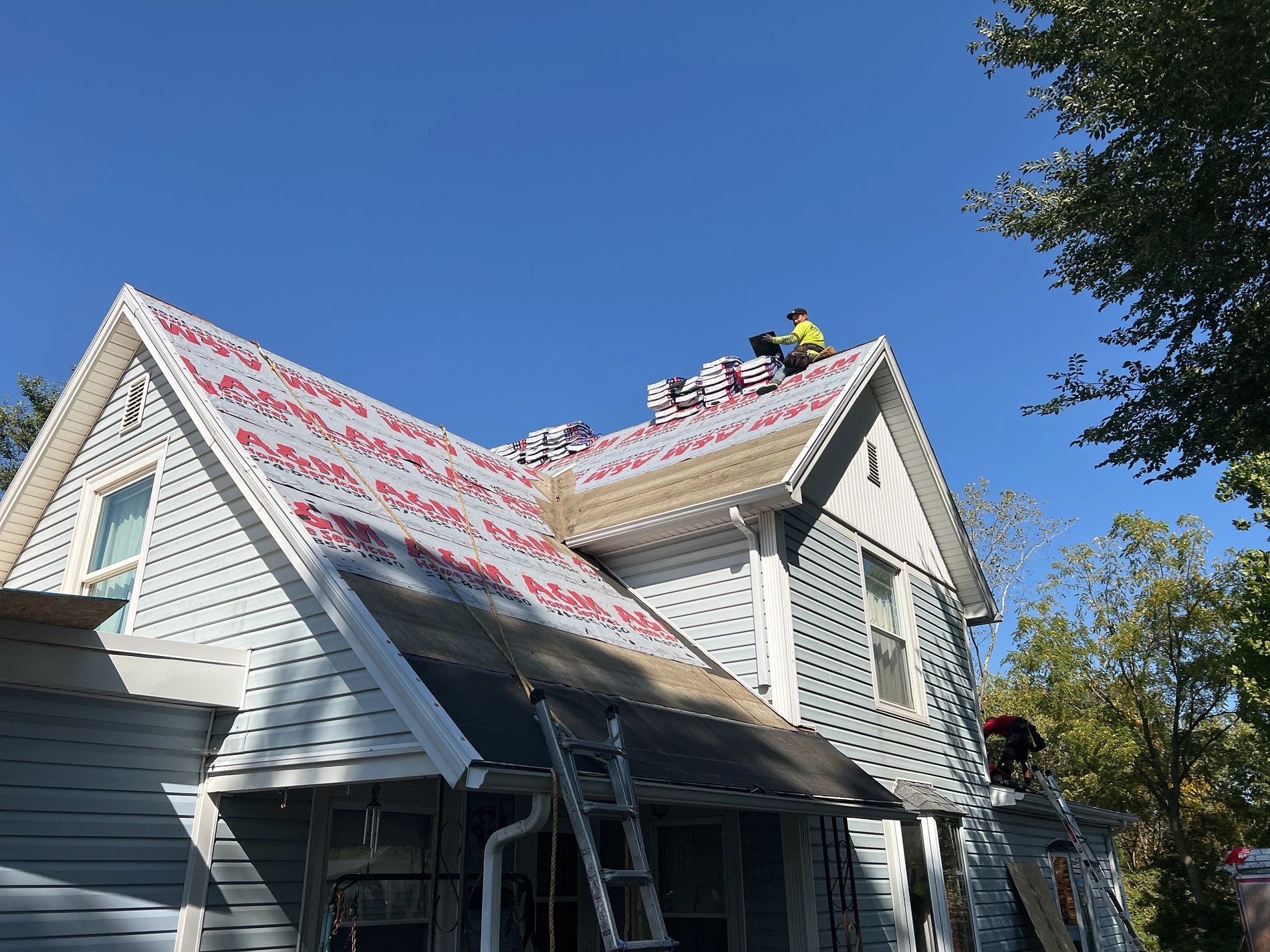 Baroda, MI 3 A roofing contractor installs new shingles on a residential roof, highlighting the quality craftsmanship of professional exterior services.